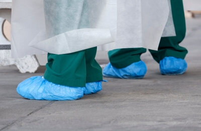 Schuhüberzieher in Verwendung Zwei Ärzte tragen Schuhüberzieher