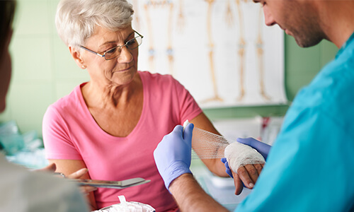Zinkleimverband kaufen Eine Person hat einen Zinkleimverband gekauft und legt diesen einer älteren Dame an
