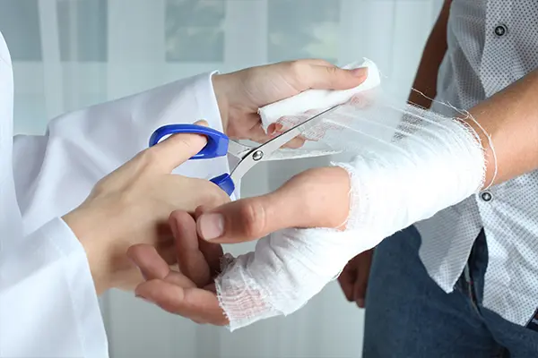 Zinkleimverband Wirkung - Abschneiden Arzt schneidet Zinkleimverband für die optimale Wirkungsweise ab.