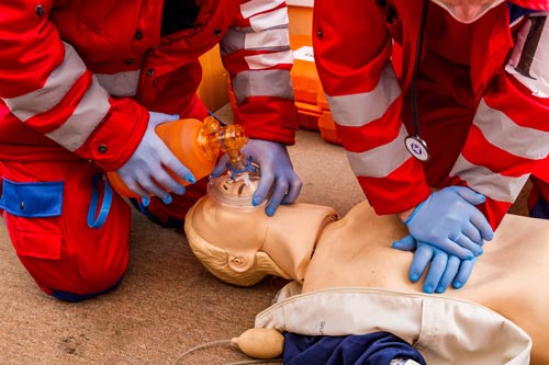 Beatmungsbeutel als Beatmungshilfe bei einem simulierten Erste-Hilfe-Einsatz Sanitäter trainieren mit Beatmungsmaske und Beatmungsbeutel an einer Übungspuppe