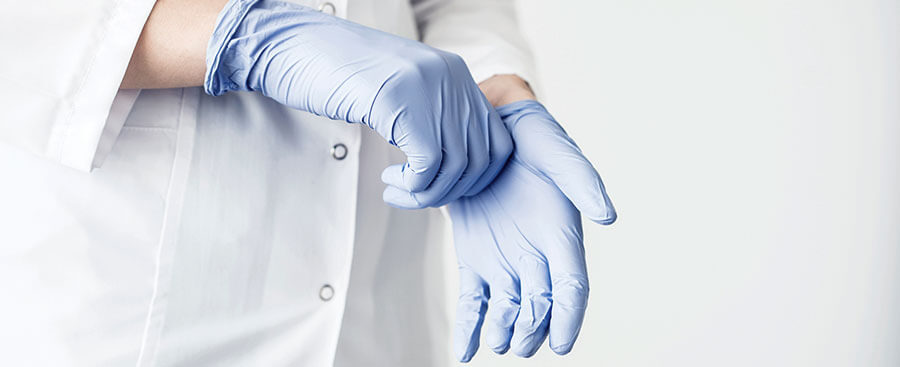 Vinyl Einmalhandschuhe im Gesundheitswesen Arzt zieht Vinyl Einmalhandschuhe an