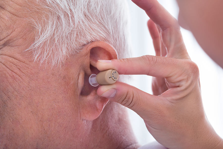 Senior trägt ein idO Hörgerät