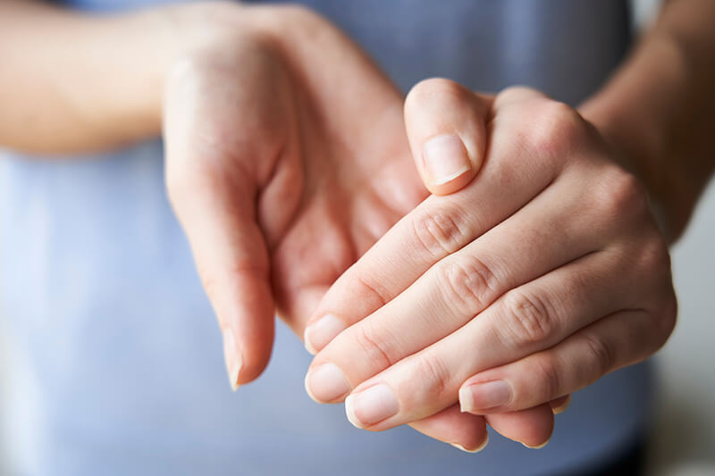 Eine Frau reibt sich die Hände mit desmanol® care ein